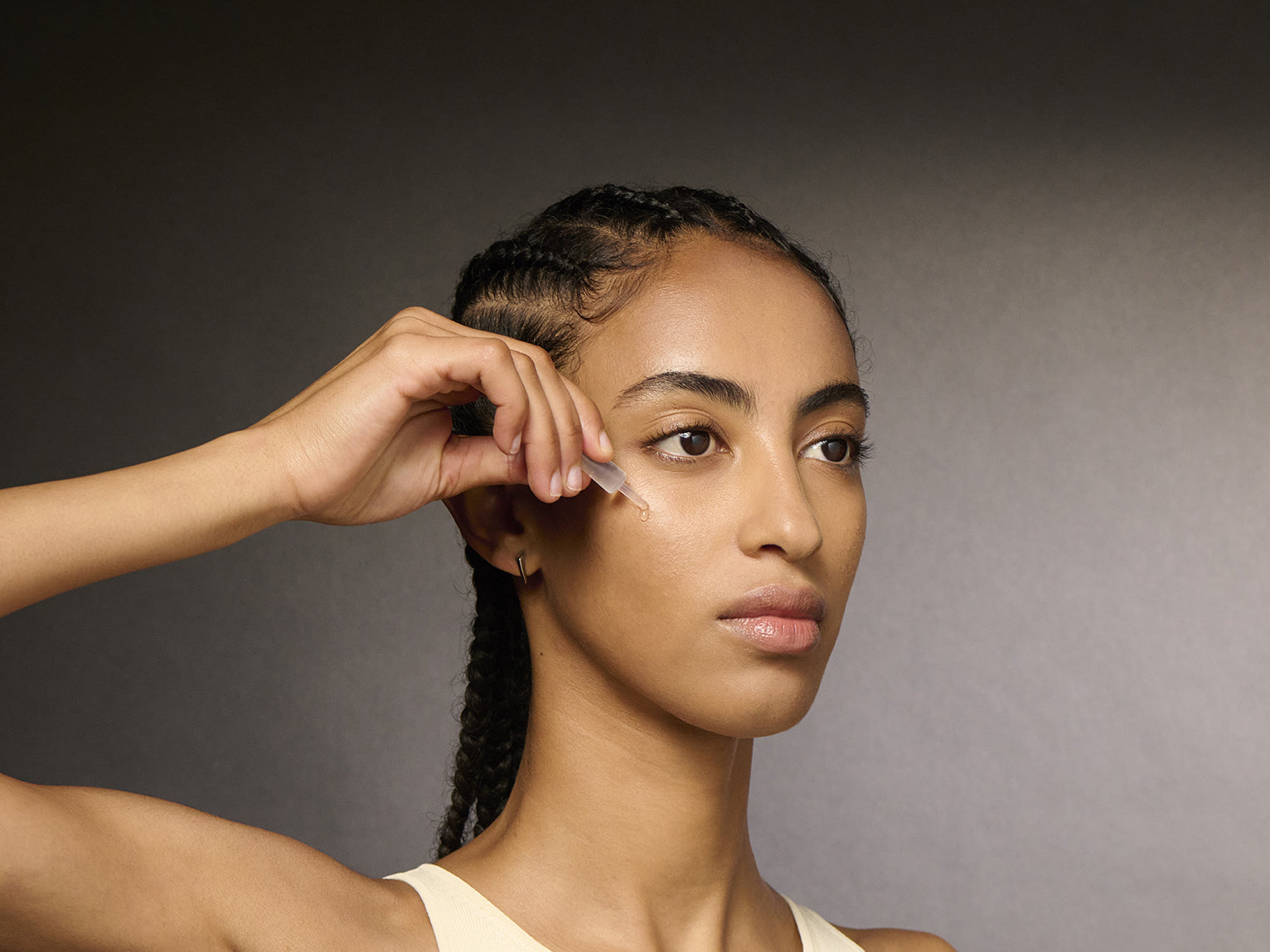 Model applying serum on her face