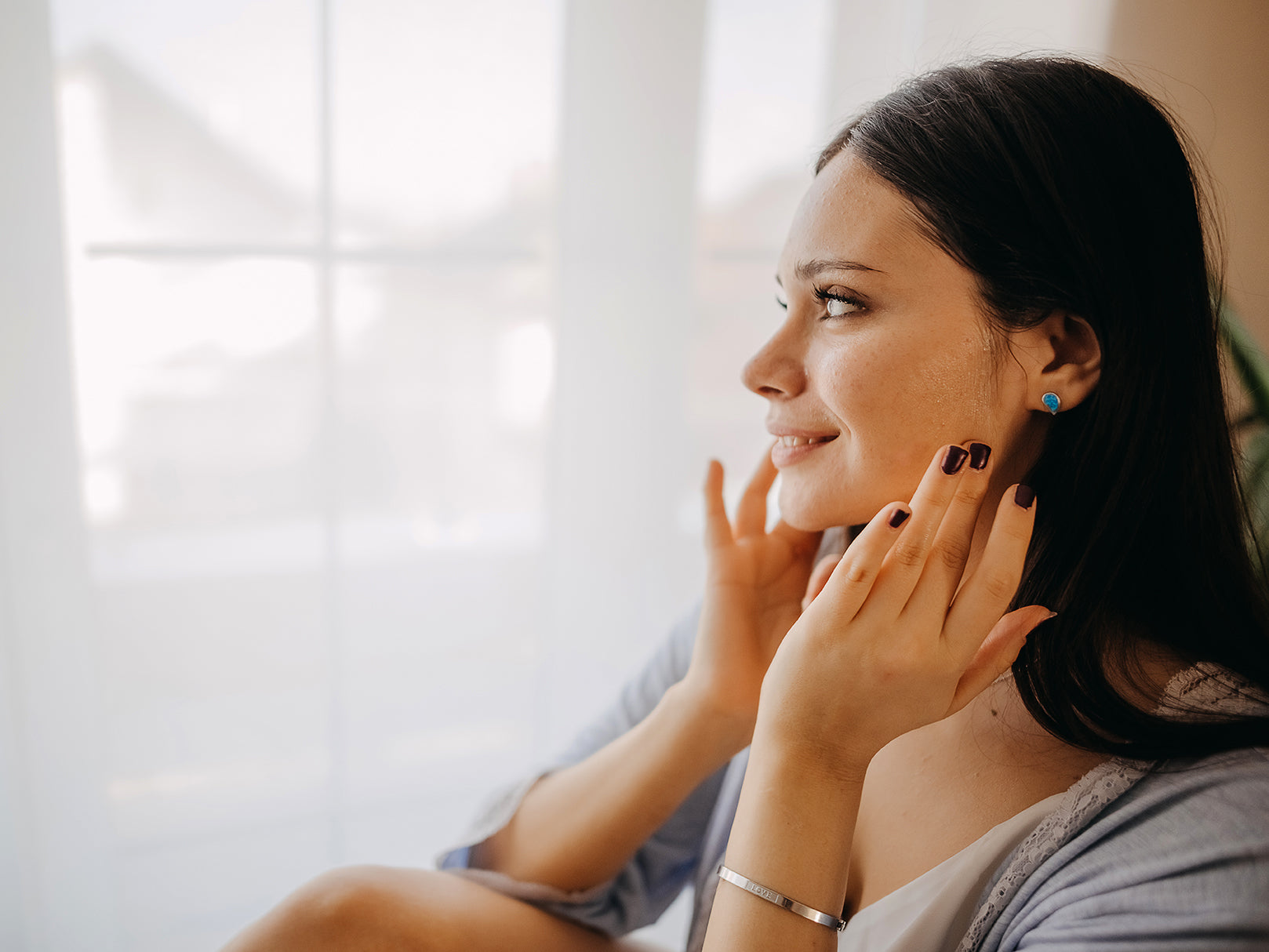 woman applying a serum on her face 